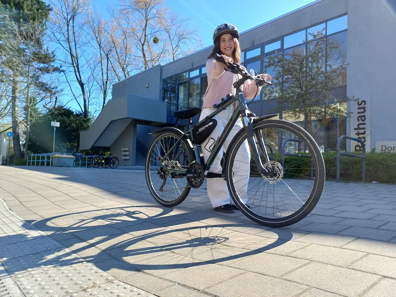 Stadtradeln in Korschenbroich. Das Bild zeigt eine Radfahrerin mit Helm in Korschenbroich vor der Verwaltung
